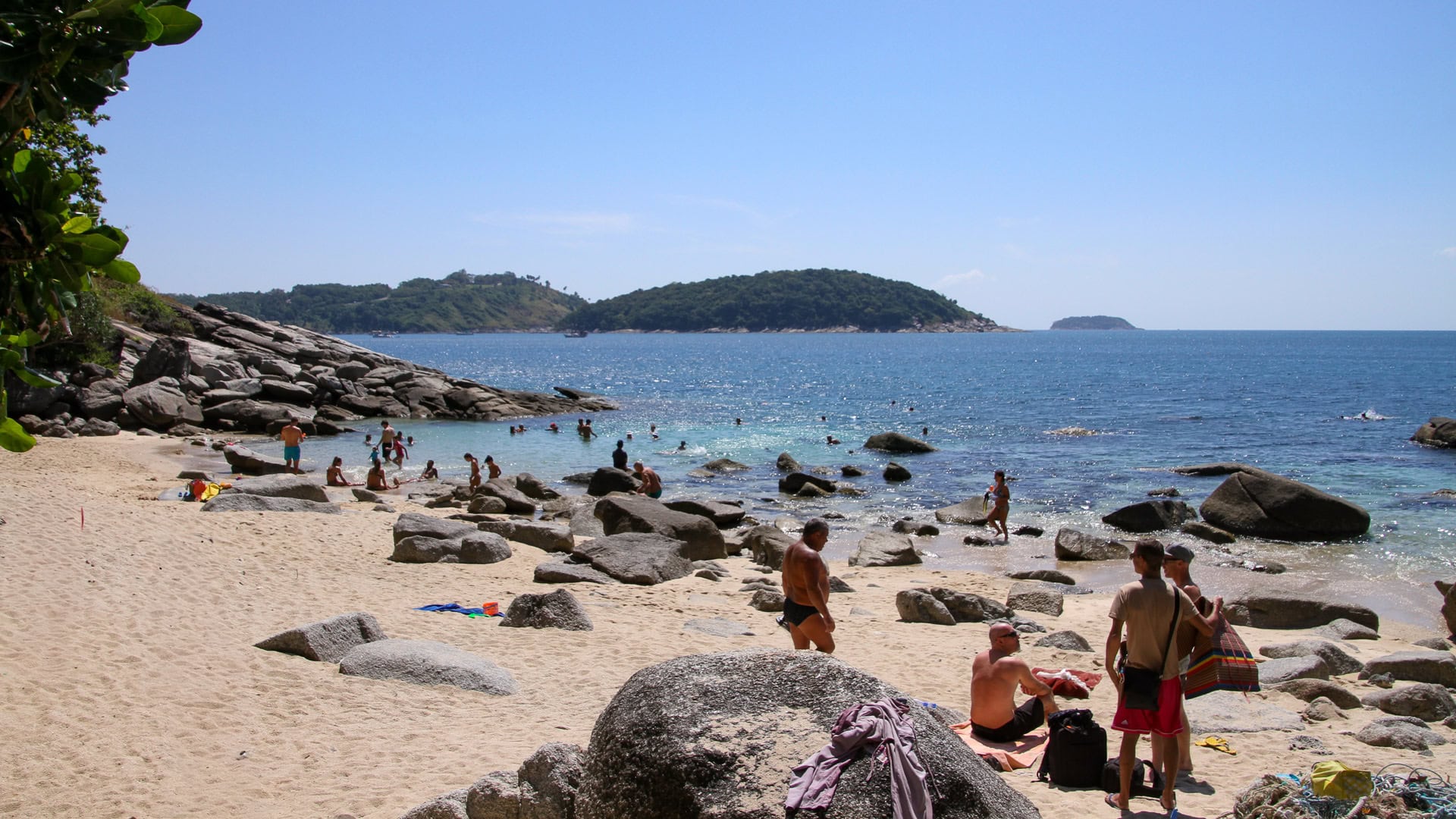 Ao Sane Beach Phuket rocky cove with swimmers in clear blue water