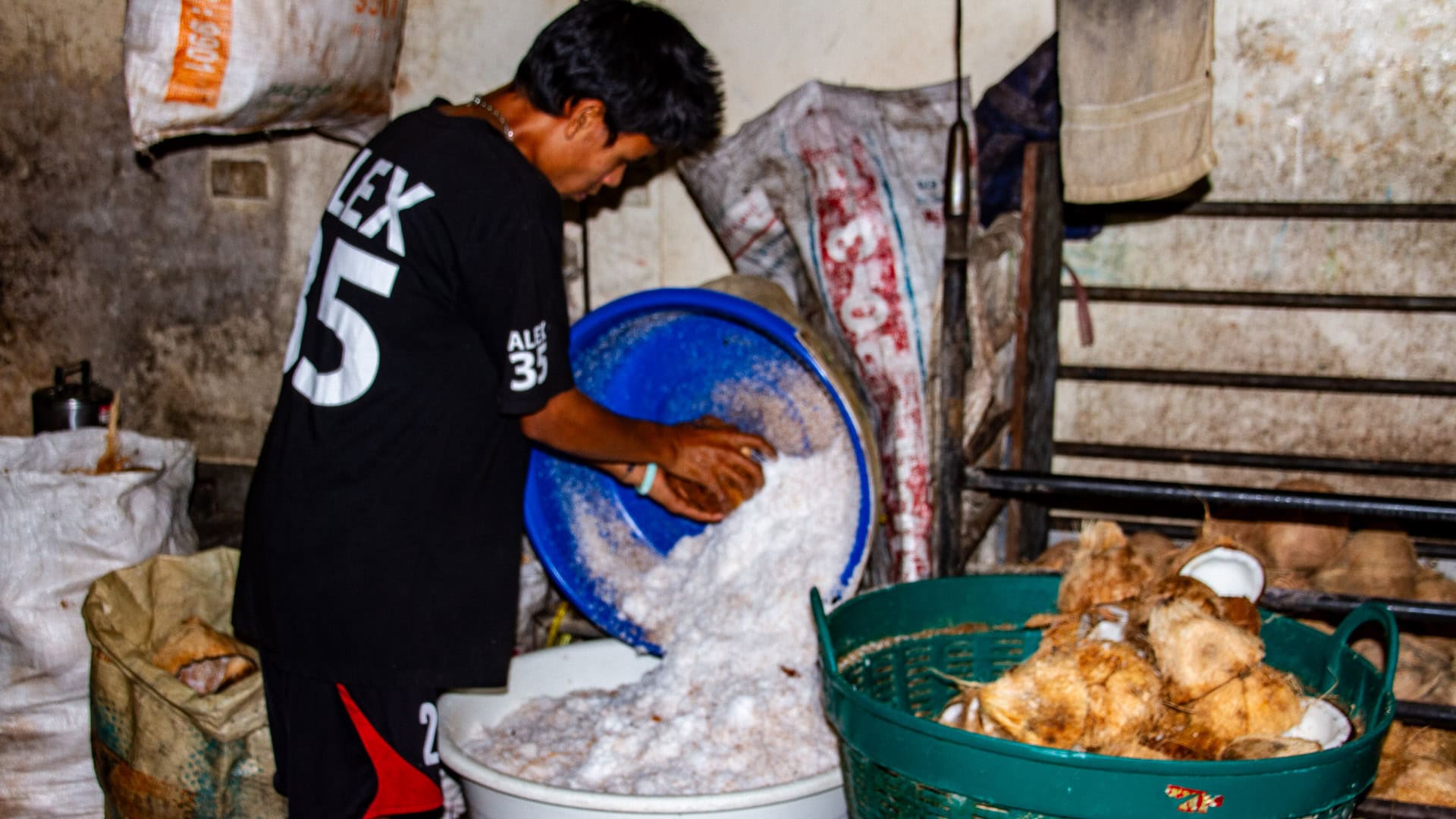 Banzaan Fresh Market Phuket coconut station with grated coconut being poured into a plastic tub for coconut milk.