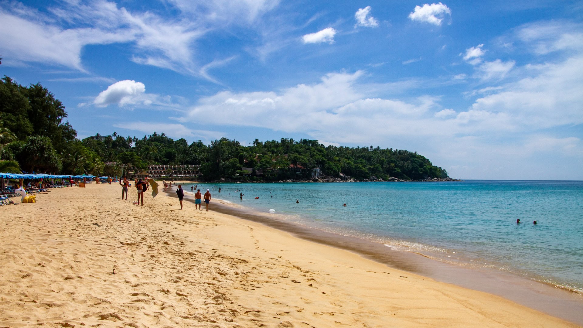 Shoreline at Karon Beach Phuket with gentle surf and distant islands