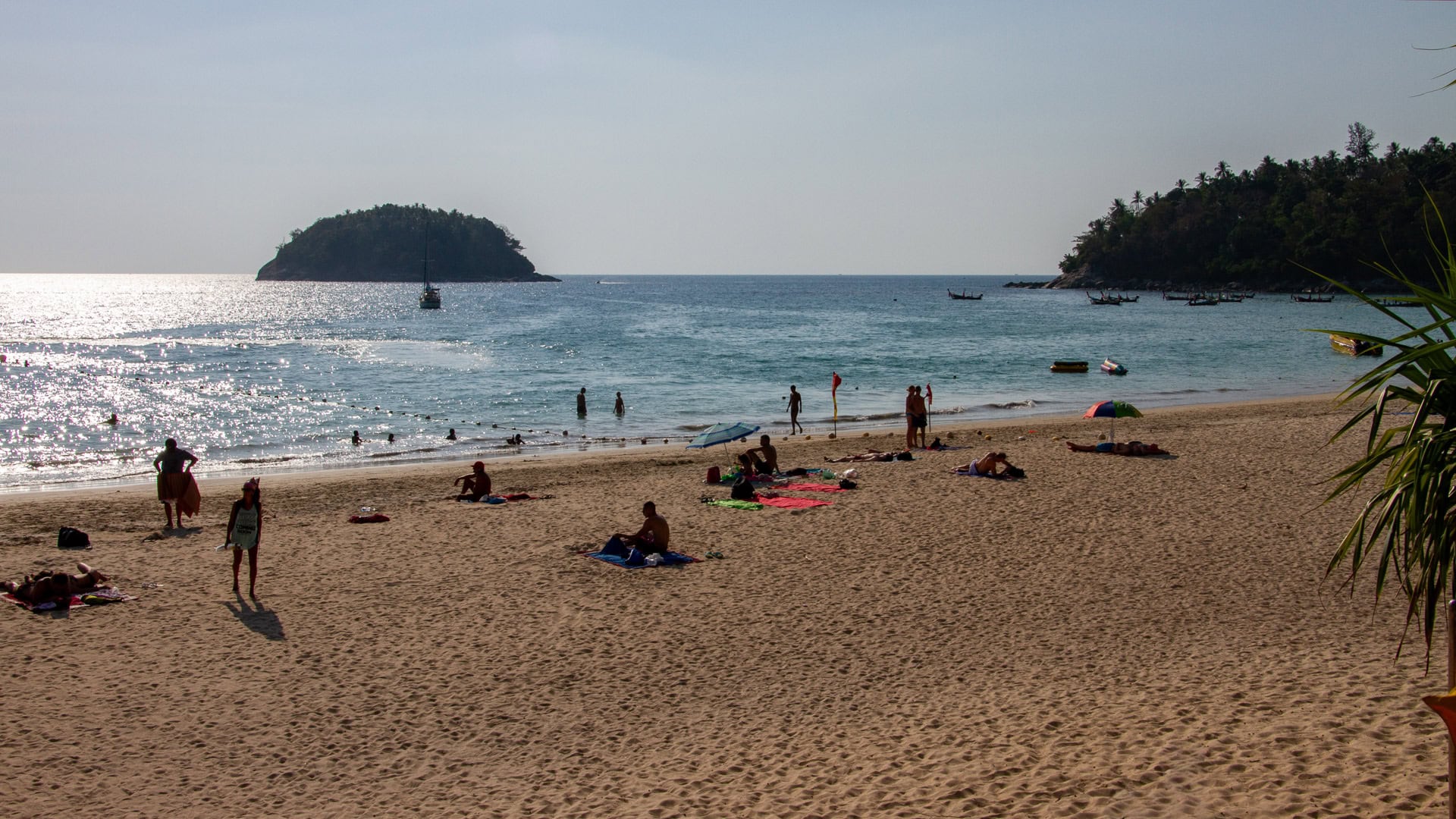 Kata Beach Phuket sandy bay with swimmers, small island offshore, and headlands