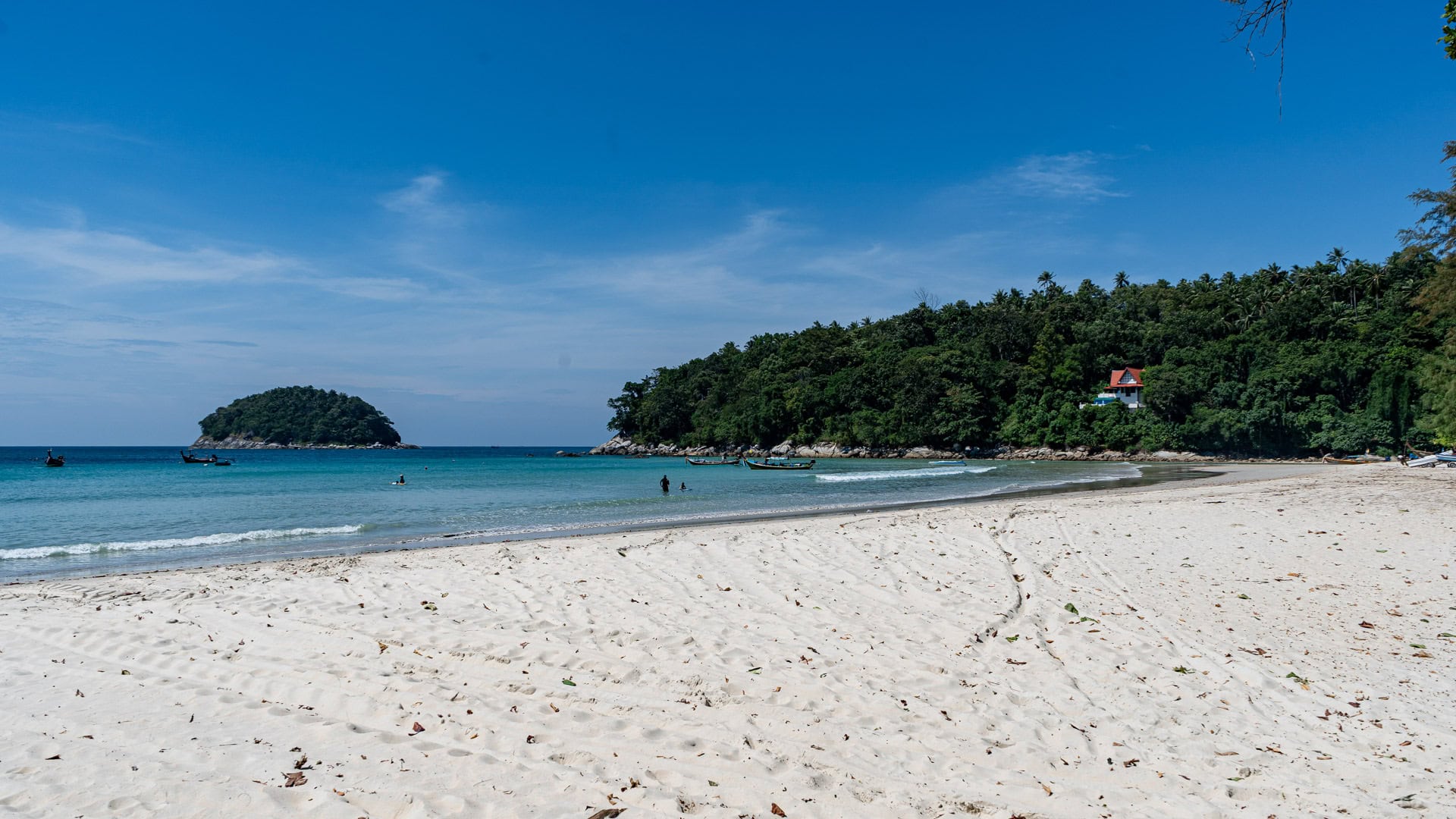 Kata Beach Phuket quiet shoreline with white sand, boats offshore, and green hillside