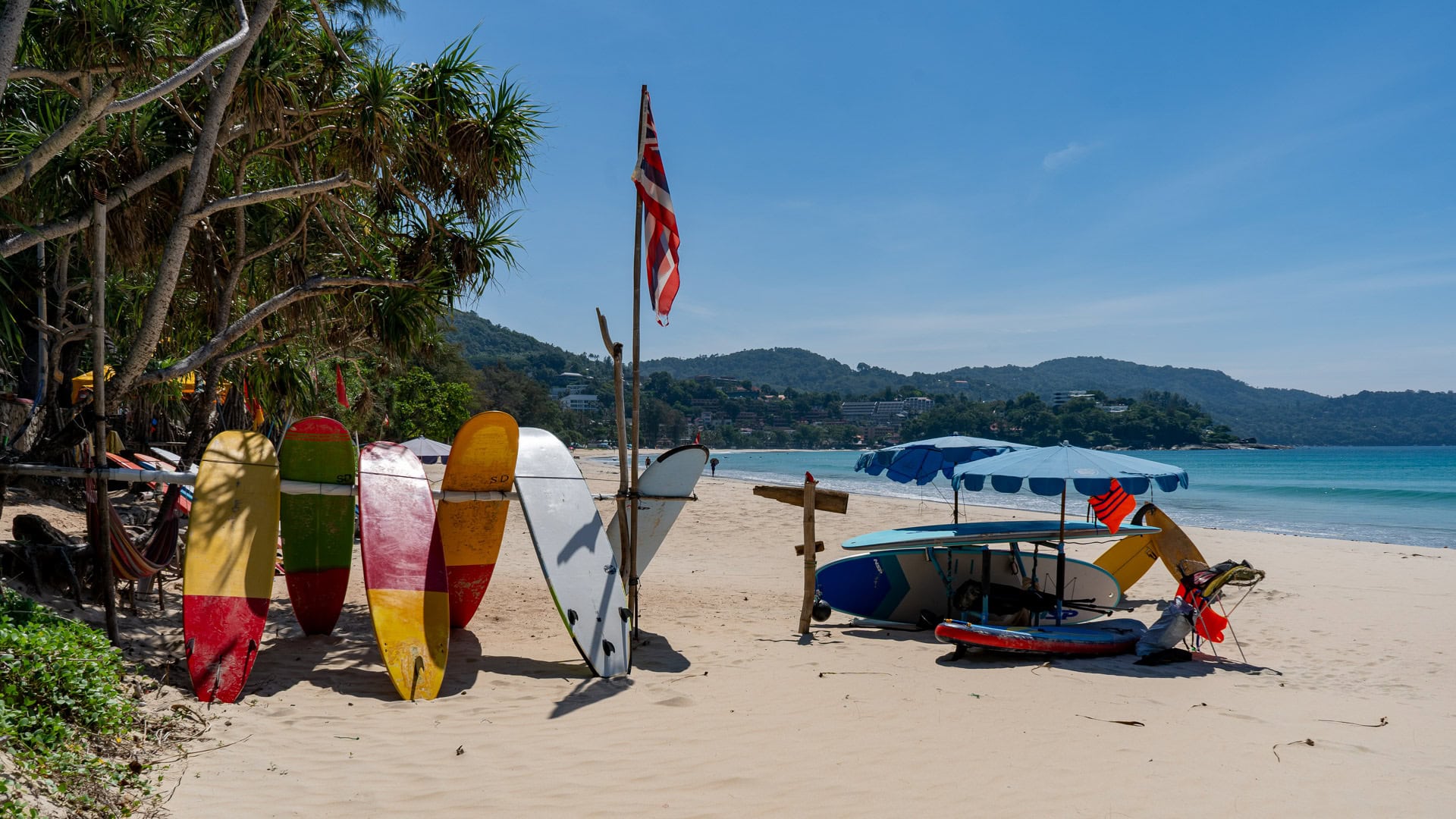 Kata Beach Phuket surfboards and umbrellas near the beach with Thai flag