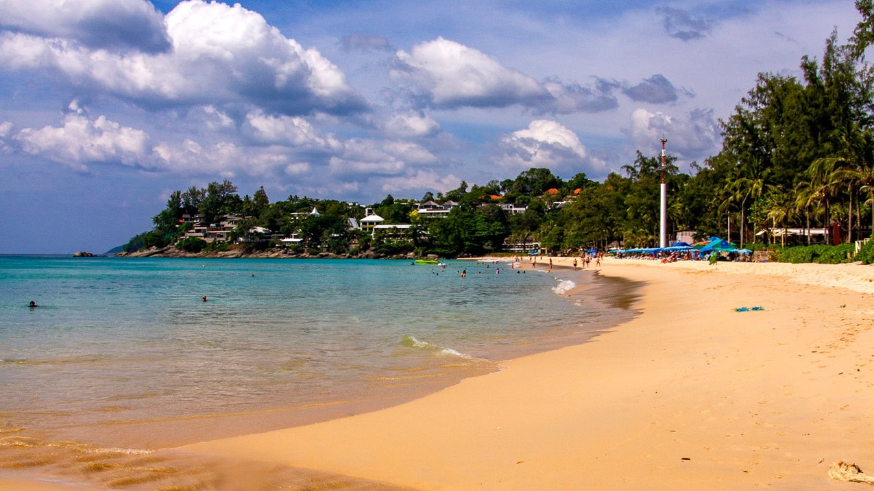 Kata Noi Beach Phuket calm bay with light waves and beachfront trees