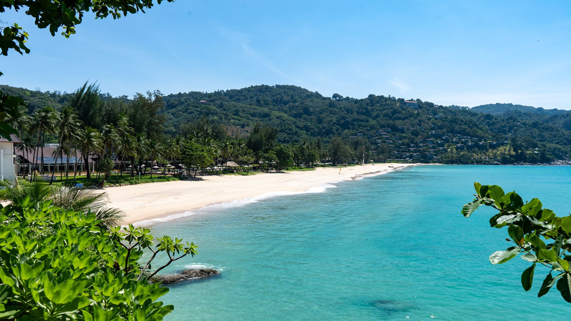 Kata Noi Beach Phuket elevated view showing curved bay, turquoise water, and resort buildings