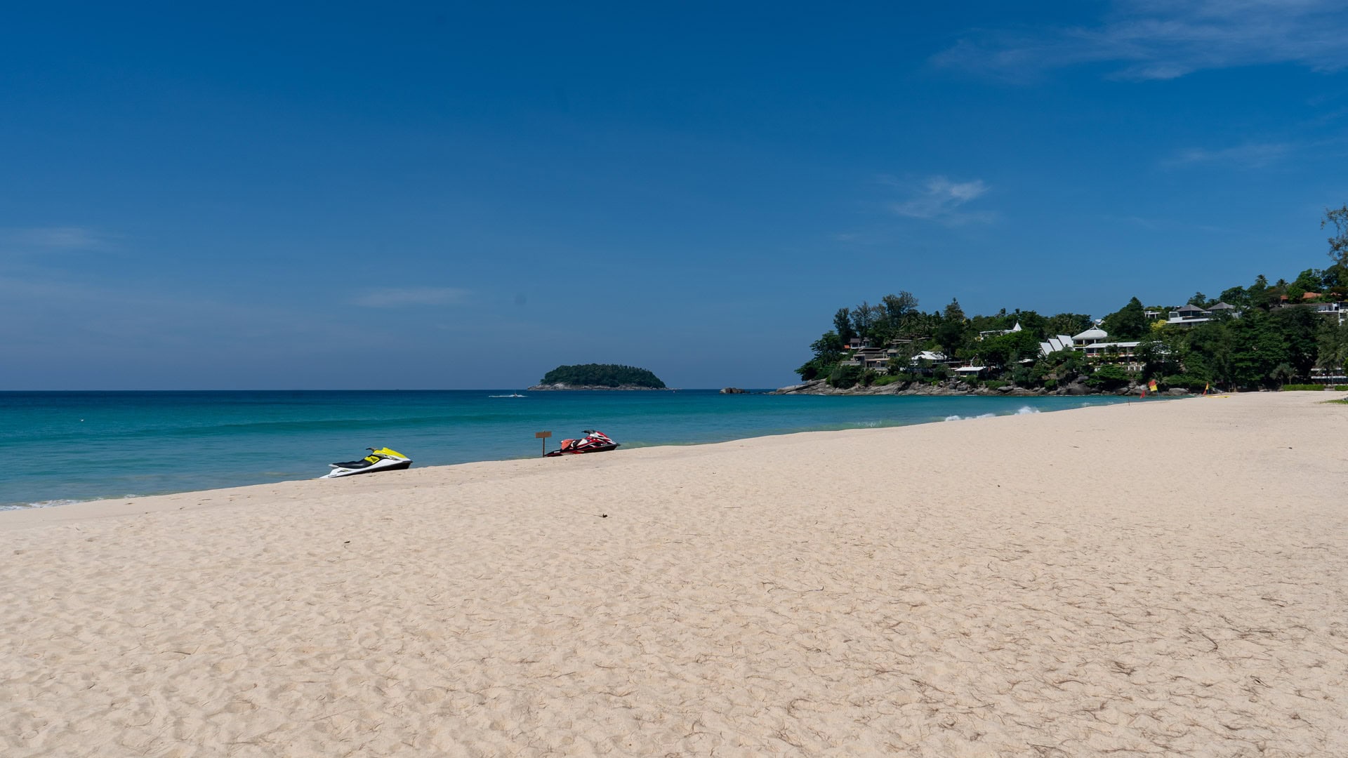 Kata Noi Beach Phuket open sandy area with jet skis parked near the waterline