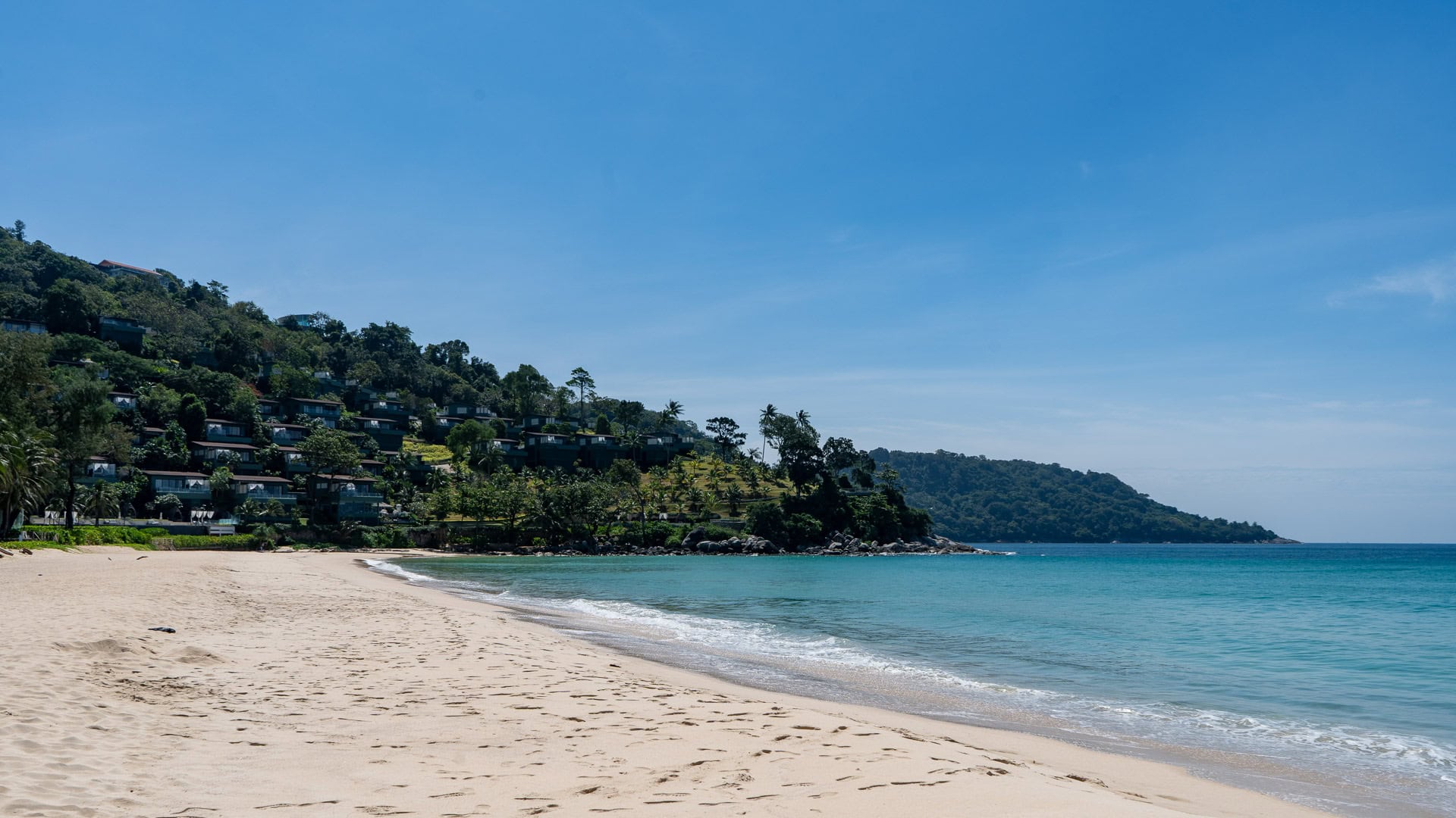 Kata Noi Beach Phuket shoreline with gentle waves and green headlands