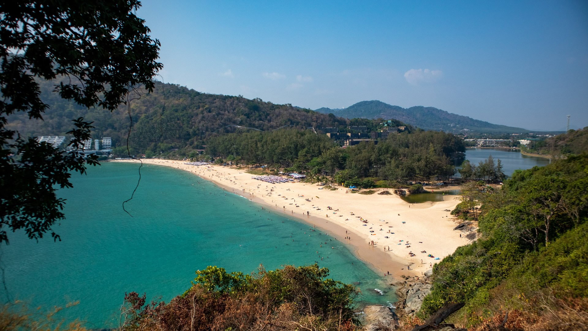 Nai Harn Beach Phuket panoramic view of long beach backed by trees and hill