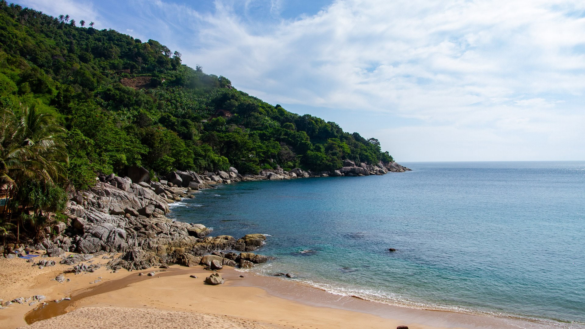 Nui Beach Phuket small sandy cove with rocky shoreline and clear blue water