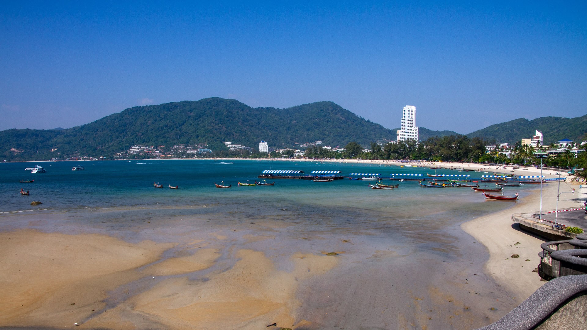 Patong Beach Phuket wide bay with longtail boats and beachfront buildings