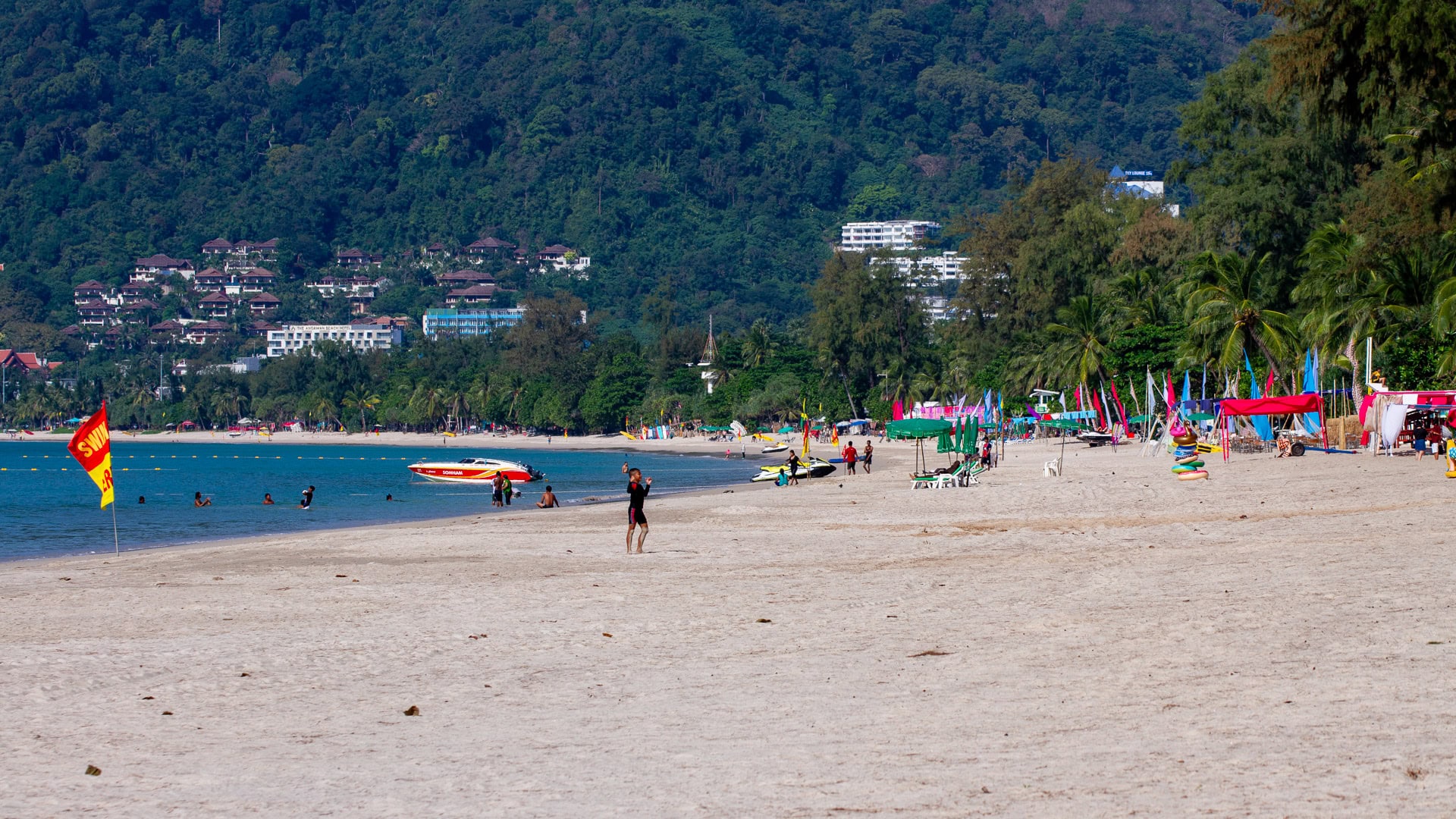 Patong Beach Phuket wide sandy beach with swimmers and activity flags