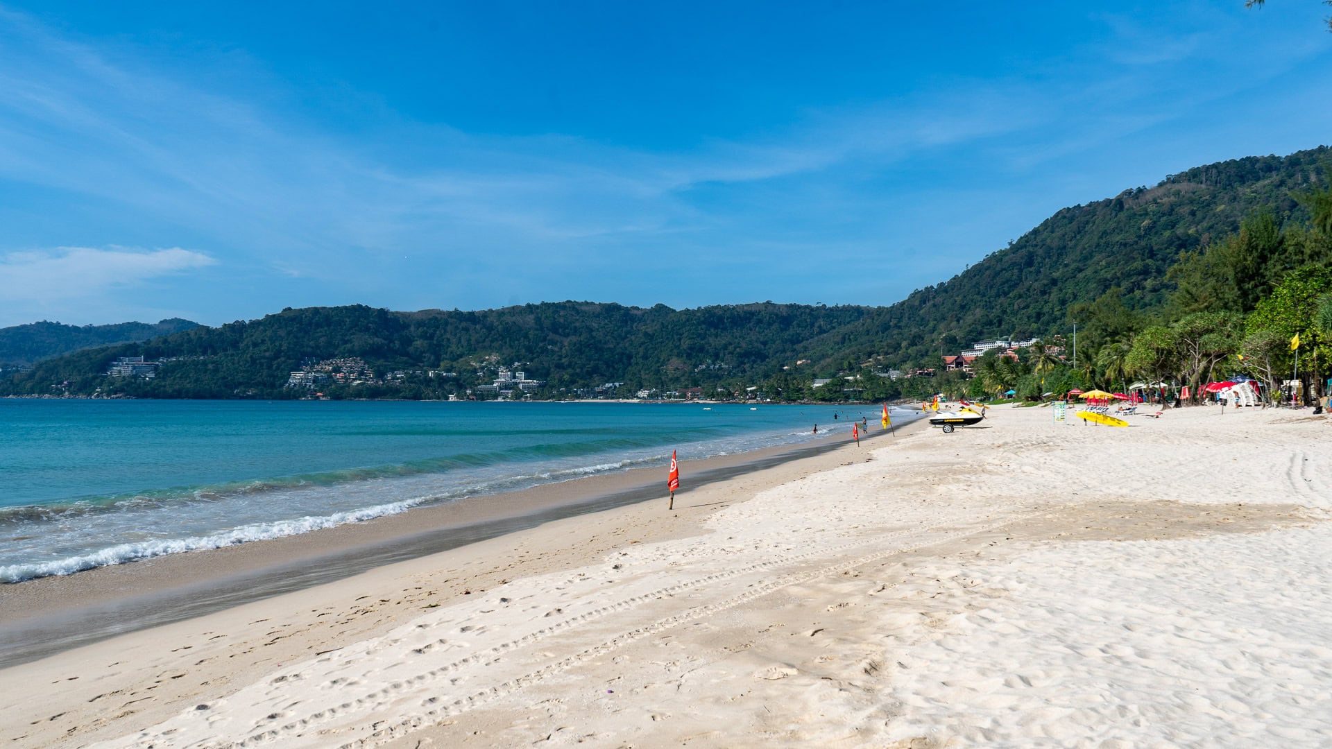 Patong Beach Phuket shoreline with gentle waves and hillside backdrop