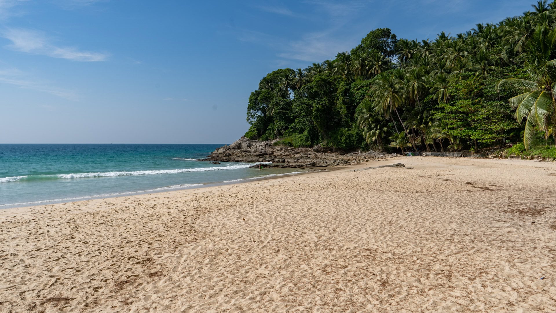 Elevated view across Surin Bay showing sand, reef patches and headland.