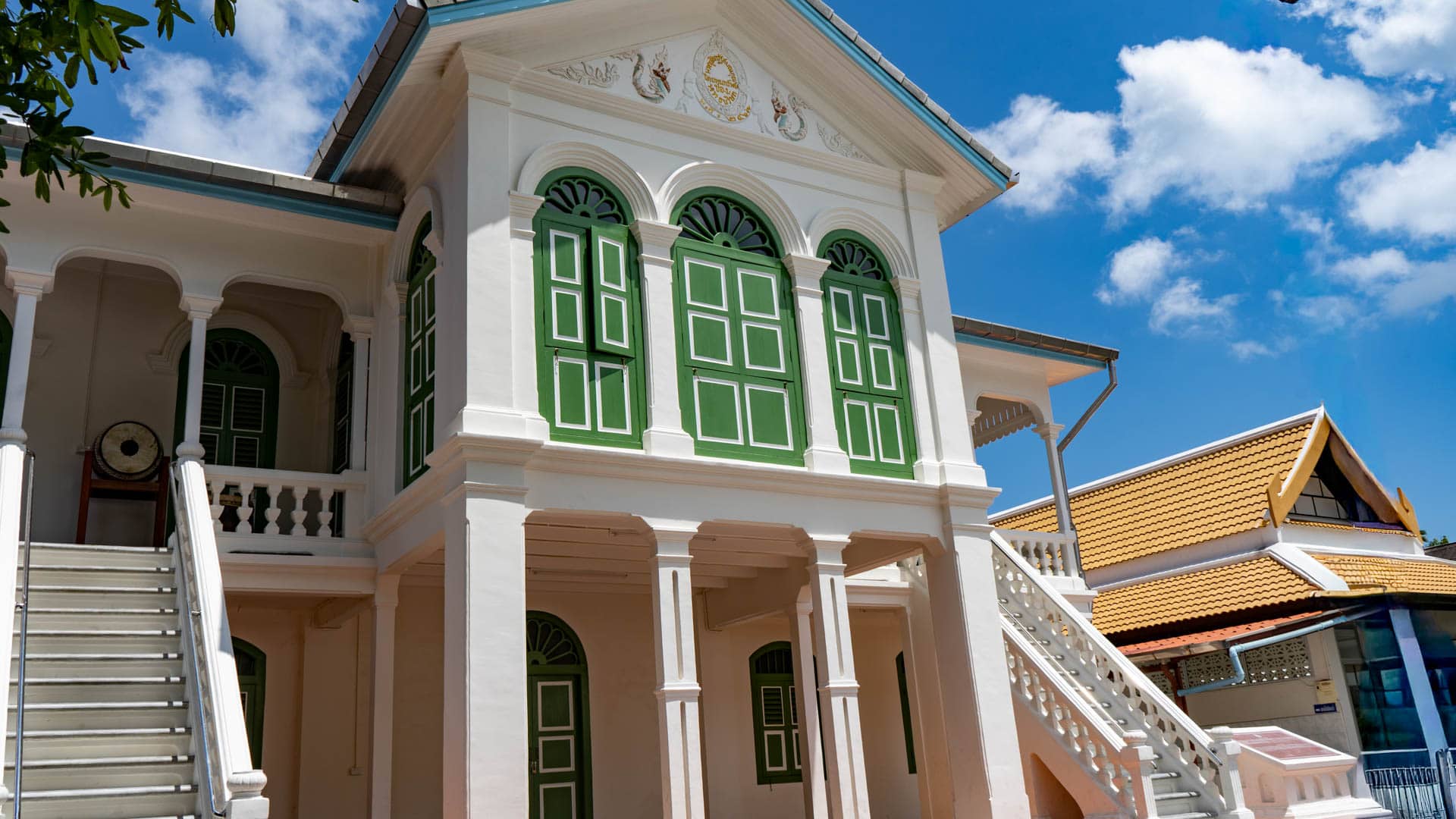 Two-storey white building with green shutters at Wat Mongkolnimit temple